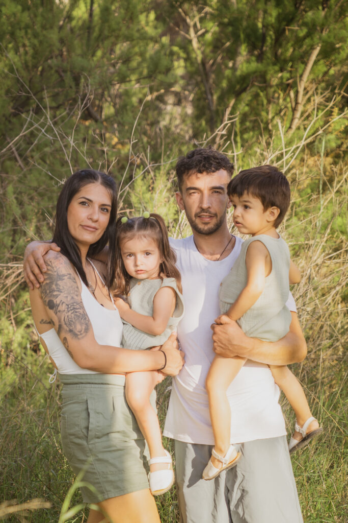 foto de familia con un niño y niña pequeños en el bosque vestidos de blanco y verde